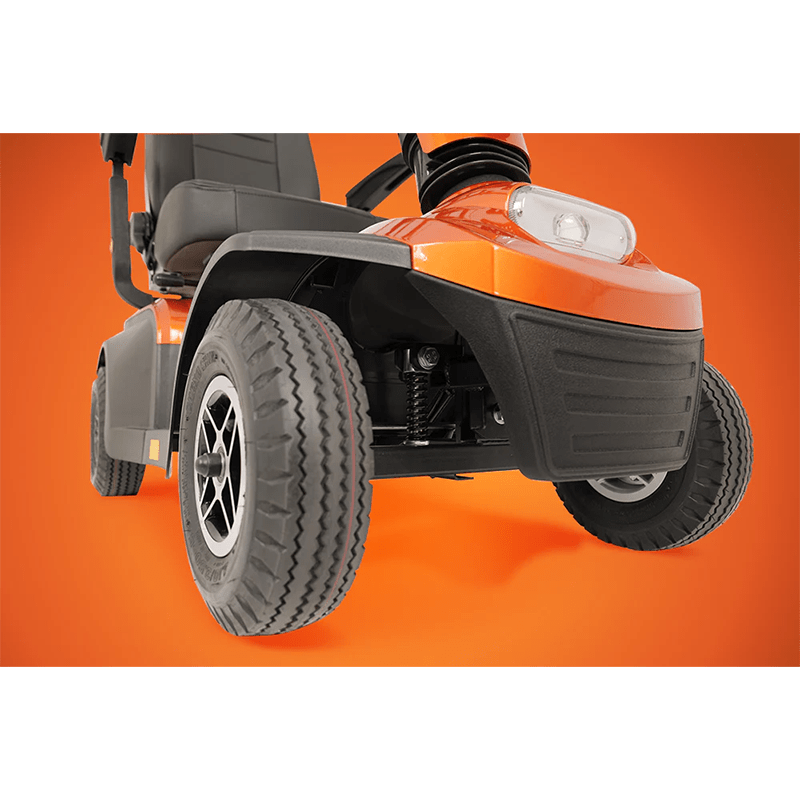 Savvy 8 - Close-up of a mobility scooter with a focus on the tire and front section against an orange background